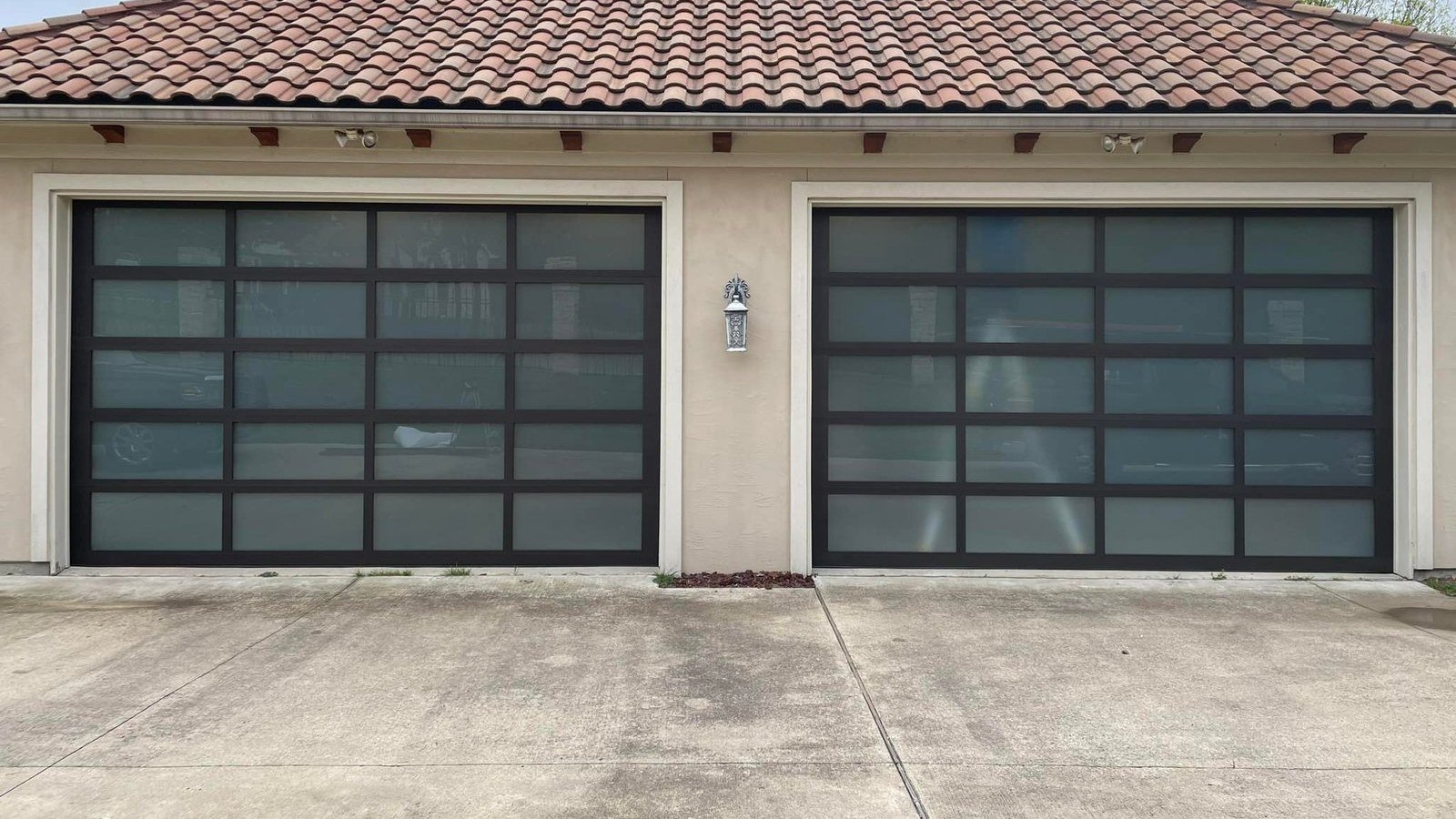 Two modern full-view glass and aluminum garage doors on a Plano, Texas home